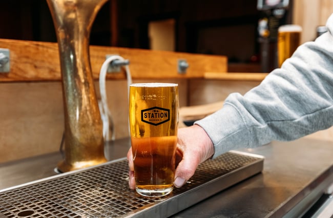 A hand holding a beer.