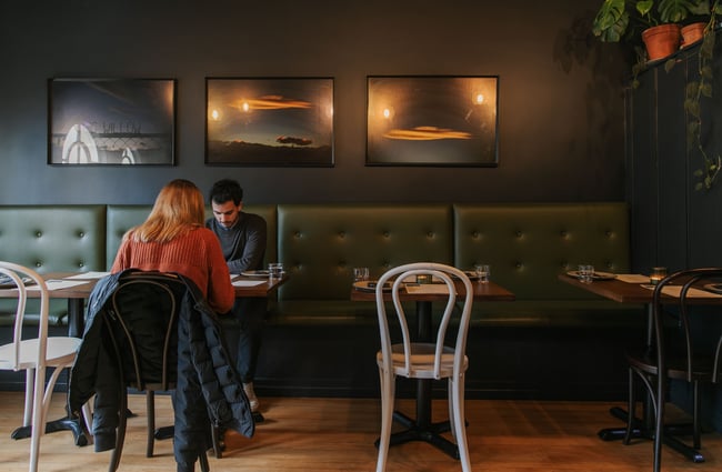 Two people sitting at a table in Story’s dark-hued upstairs area.
