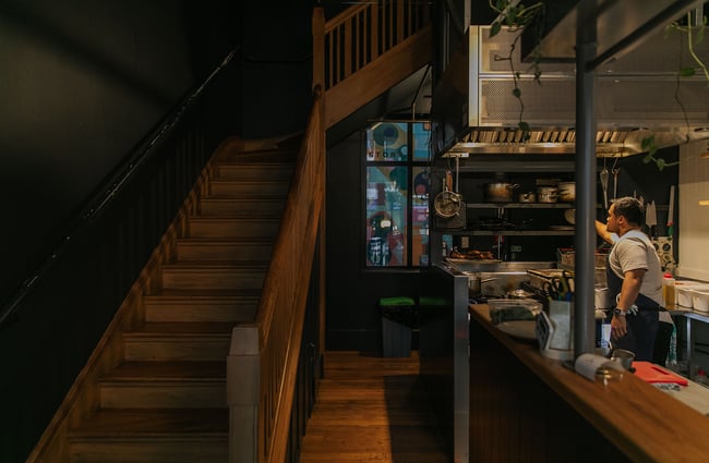 The kitchen at Story beside the wooden staircase up to the dining room.