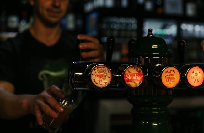 Man pouring beer into glass from tap at Strawberry Tree.
