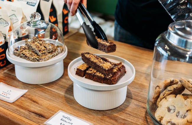 A pair of tongs is used to select a slice on the counter at Sublime Coffee Roasters.