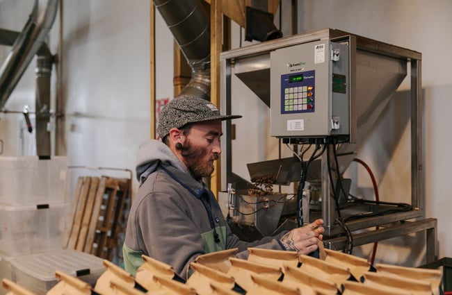 Man working on coffee roasting equipment at Sublime Roastery and Brew Bar.