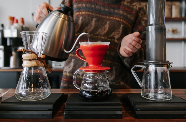 Pouring hot water into coffee brew pots at Sublime Roastery and Brew Bar.