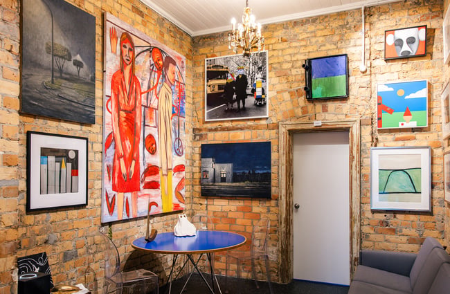 Art on exposed brick wall at Suite Gallery in Auckland