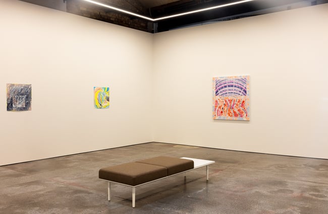 Colourful paintings on white walls.