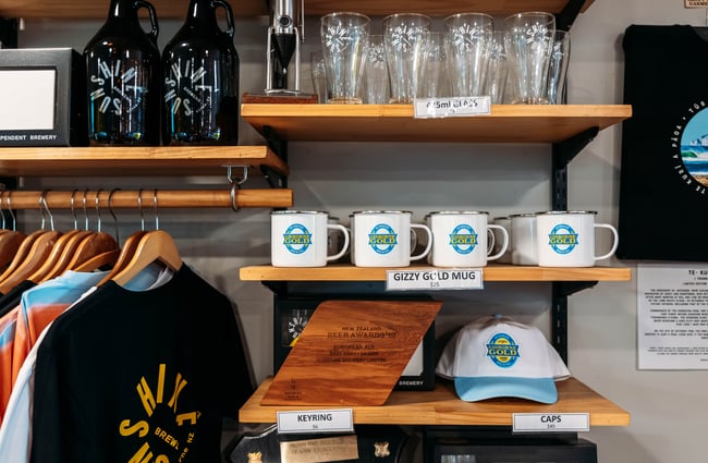 A close up of hats, t-shirts and mugs on display.