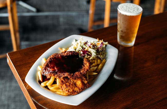 A close up of chips and fried chicken on a table.