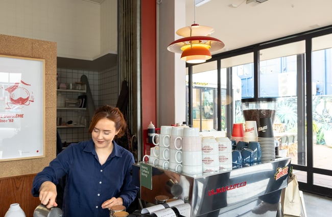 Barista behind the coffee machine at Supreme Supreme.