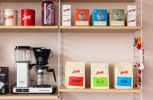 A range of coffee products for sale are displayed on a shelf at Supreme Supreme.