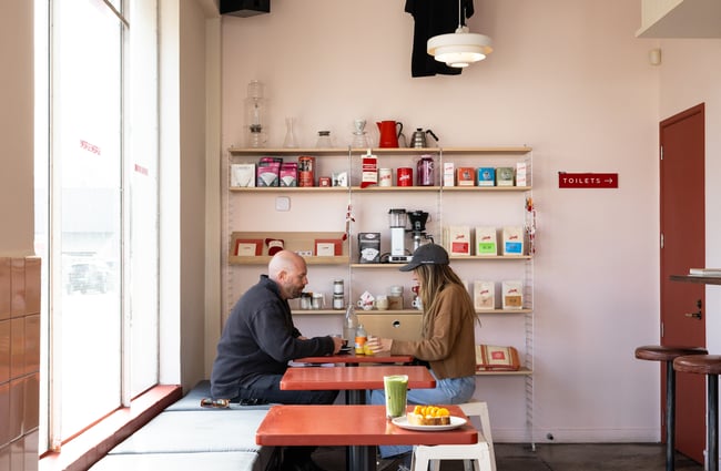 A couple is sitting at a table in the cafe space at Supreme Supreme.
