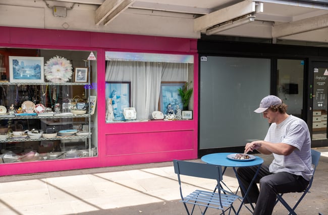 Customer sitting outside the waffle shop at a table eating waffles.