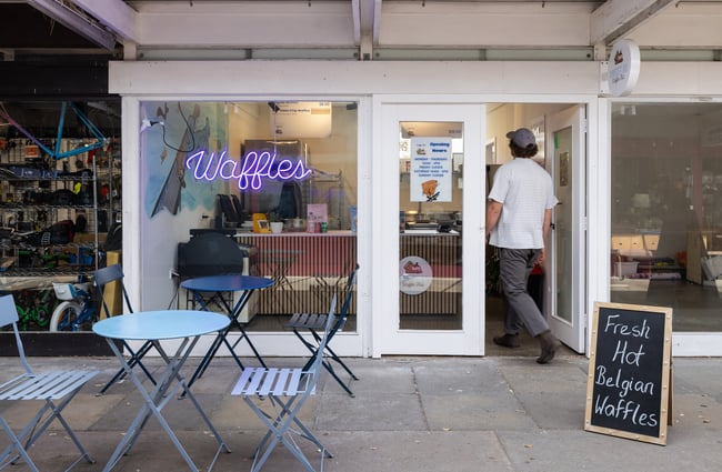 A customer walks in the front door of Sweet As Waffles.