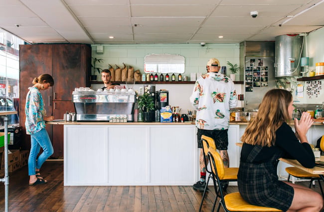Interior with white coffee machine and shelves behind the counter.