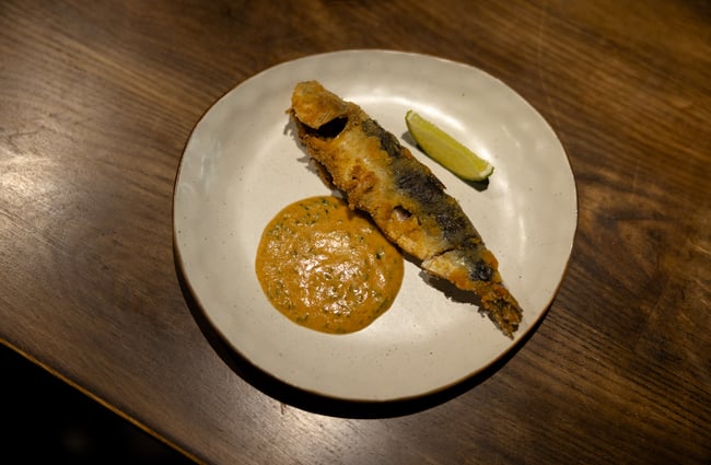 A whole deep fried fish on plate.