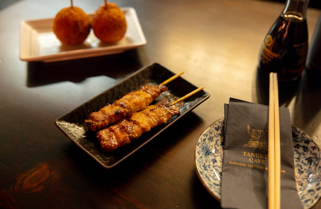 A close up of a cooked chicken skewer on a plate.