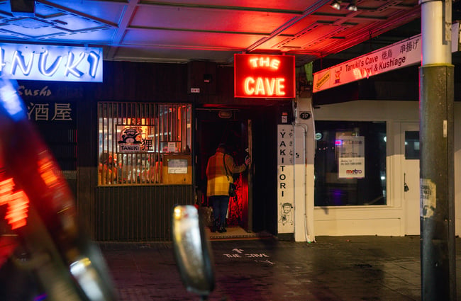 A customer walking into 'The Cave' at night.