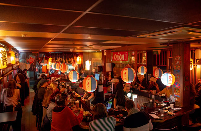 A packed restaurant on a dark night.