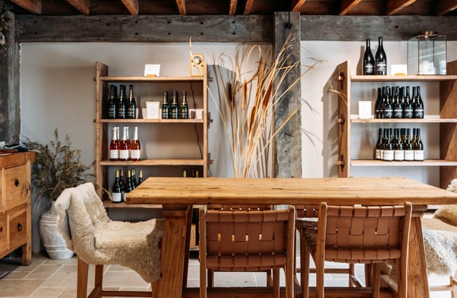 Wooden table and chairs with shelves in the background at Tarras Village.