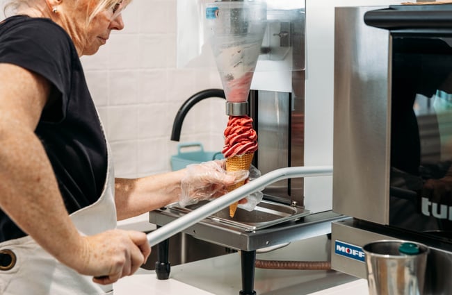 Woman making a real fruit ice cream at the machine in Tarras Village.
