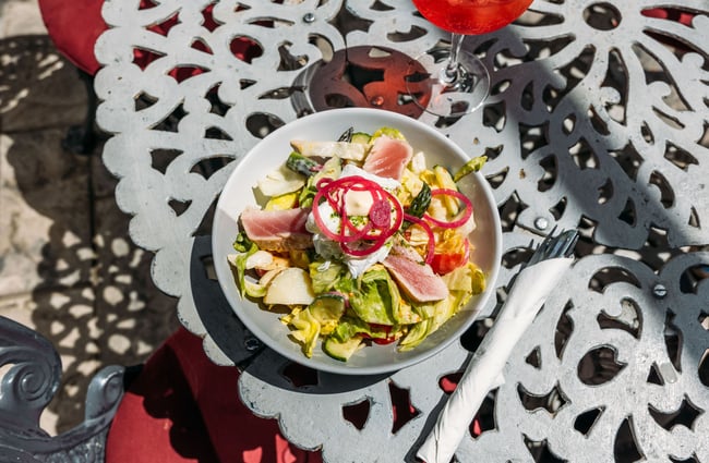 Fresh tuna salad and aperol spritz on an outdoor French style table