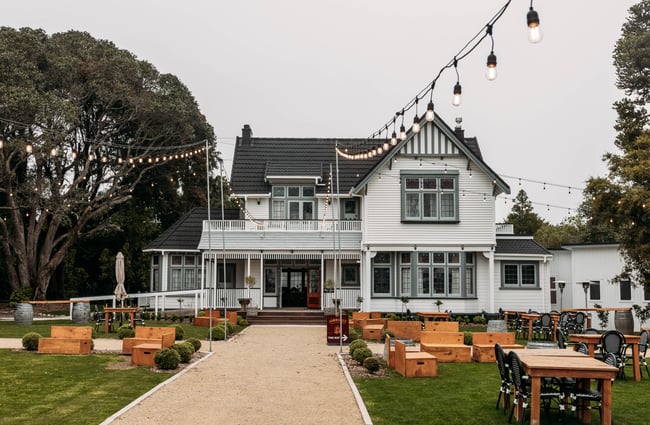 Character building exterior of Tatum, fairy lights hanging in the garden area and outdoor furniture set up.
