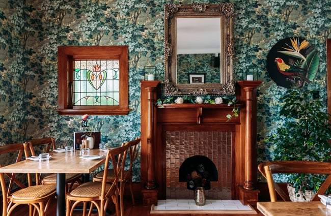 Fireplace and table and chairs in the dining room at Tatum.