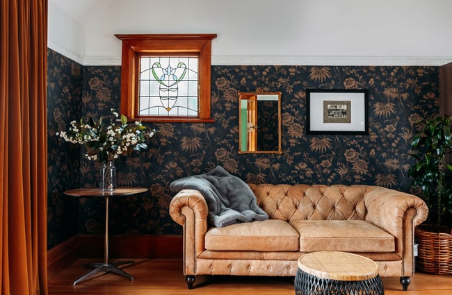 Old-fashioned sofa with decorative wallpaper in the background at Tatum.
