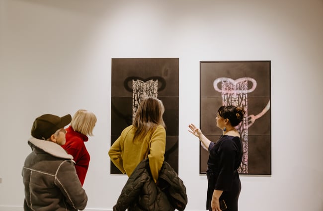 Gallery visitors looking at art on the walls at Te Atamira.