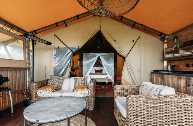 Outdoor lounge and bedroom view at Te Hāpua Coastal Glamping.
