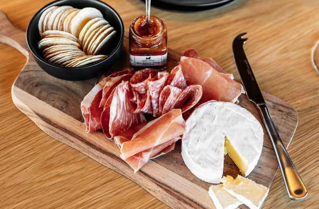 Cheese and meat on a board.