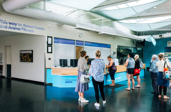 People waiting at a counter to enter the arena.