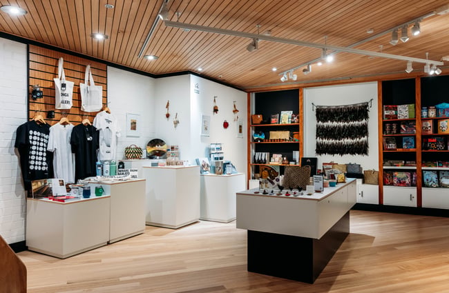 Gift shop with products on shelves and display tables at Waikato Museum.