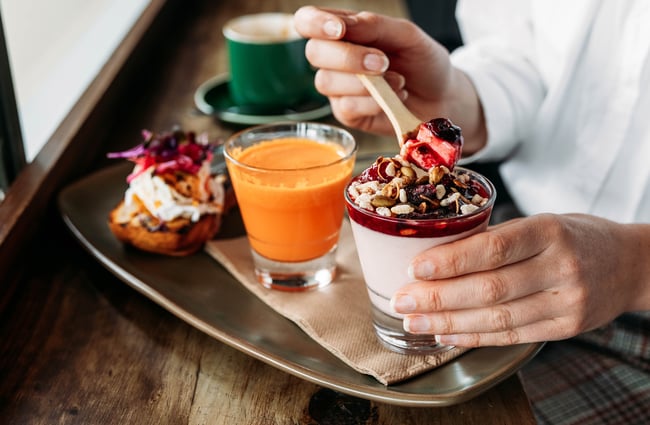 Person putting a spoon through breakfast pudding at Tees St in Ōamaru