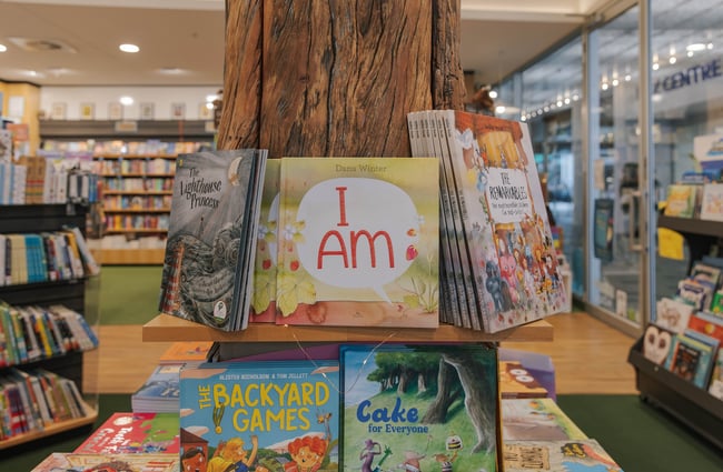Close up of book titles displayed around the tree trunk in the middle of the store.