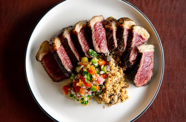 A plate of meat and salad on a plate.