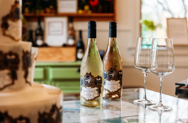 Two bottles of white wine on a table with two glasses at Terra Sancta.