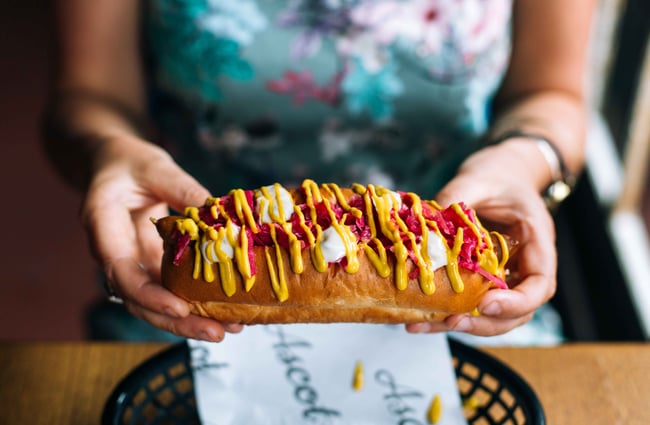 Woman holding hotdog.