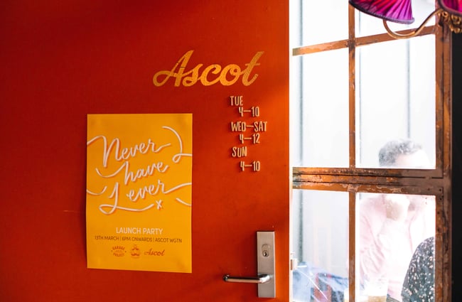 Orange door with yellow signage for The Ascot.