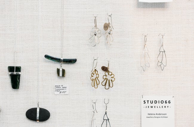 Jewellery hanging up on a white board.