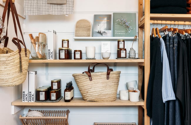 A close up of a shopping bag and candles on display inside a retail store.