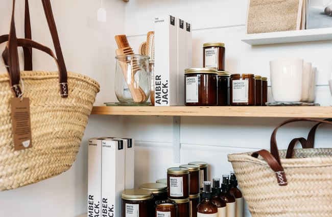 A close up of candles and shopping bags on display on shelves.