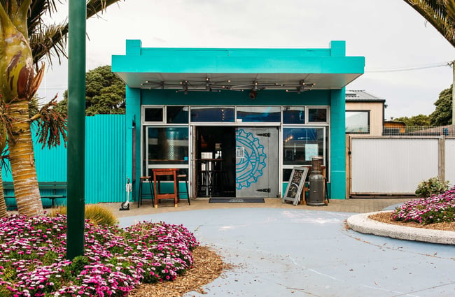 The exterior of The Beer Engine with a tall wooden table out the front.