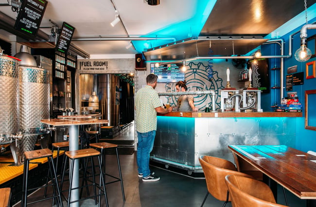 The interior of The Beer Engine where a man is standing at the counter.