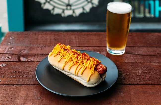 An image of a American hot dog covered in ketchup and mustard.