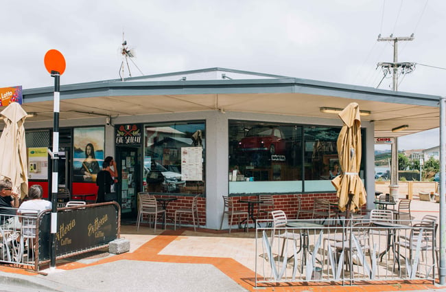 Exterior corner shop with exterior tables and umbrellas.