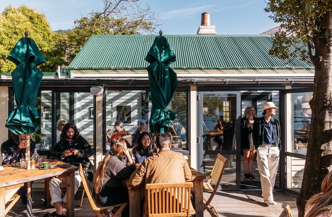 People dining outside a cafe on a sunny day.