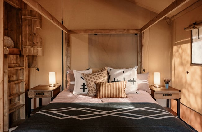 A made up bed inside a cabin.