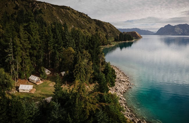 A view of cabins next to a lake photographed from above.