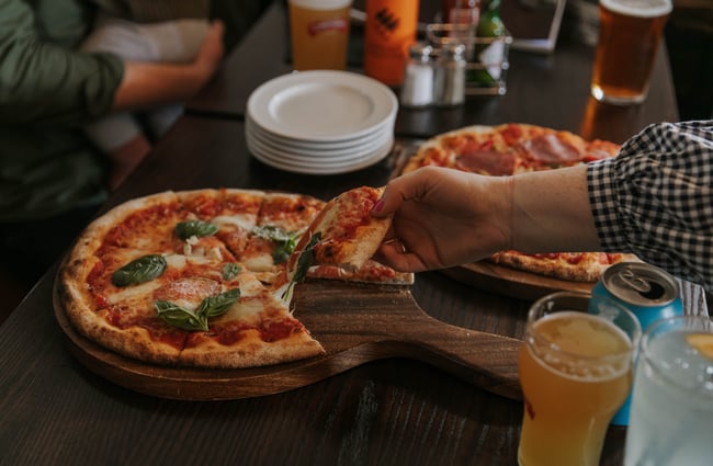 A hand holding a pizza slice.