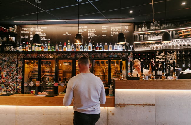 Man ordering a beer at the bar at Craft Embassy.